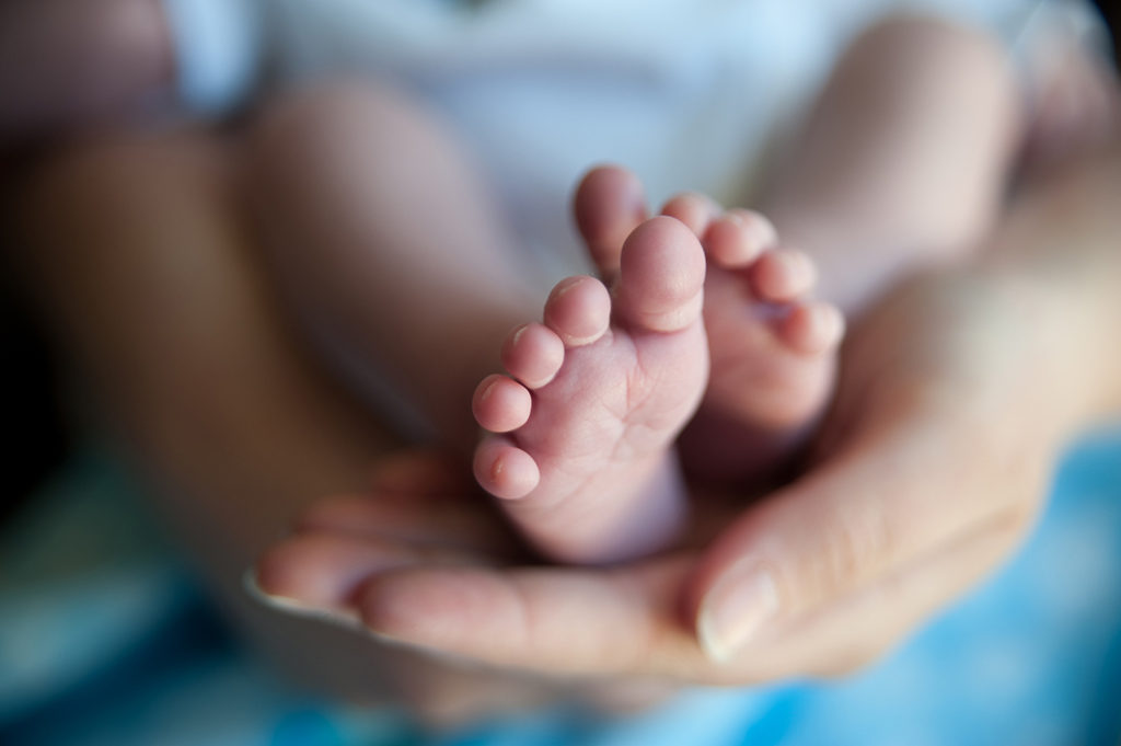 A mother holing her sons feet